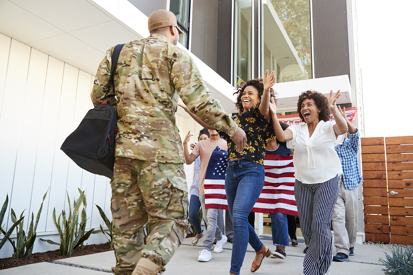 Family welcoming back millennial black soldier   returning home,low angle view