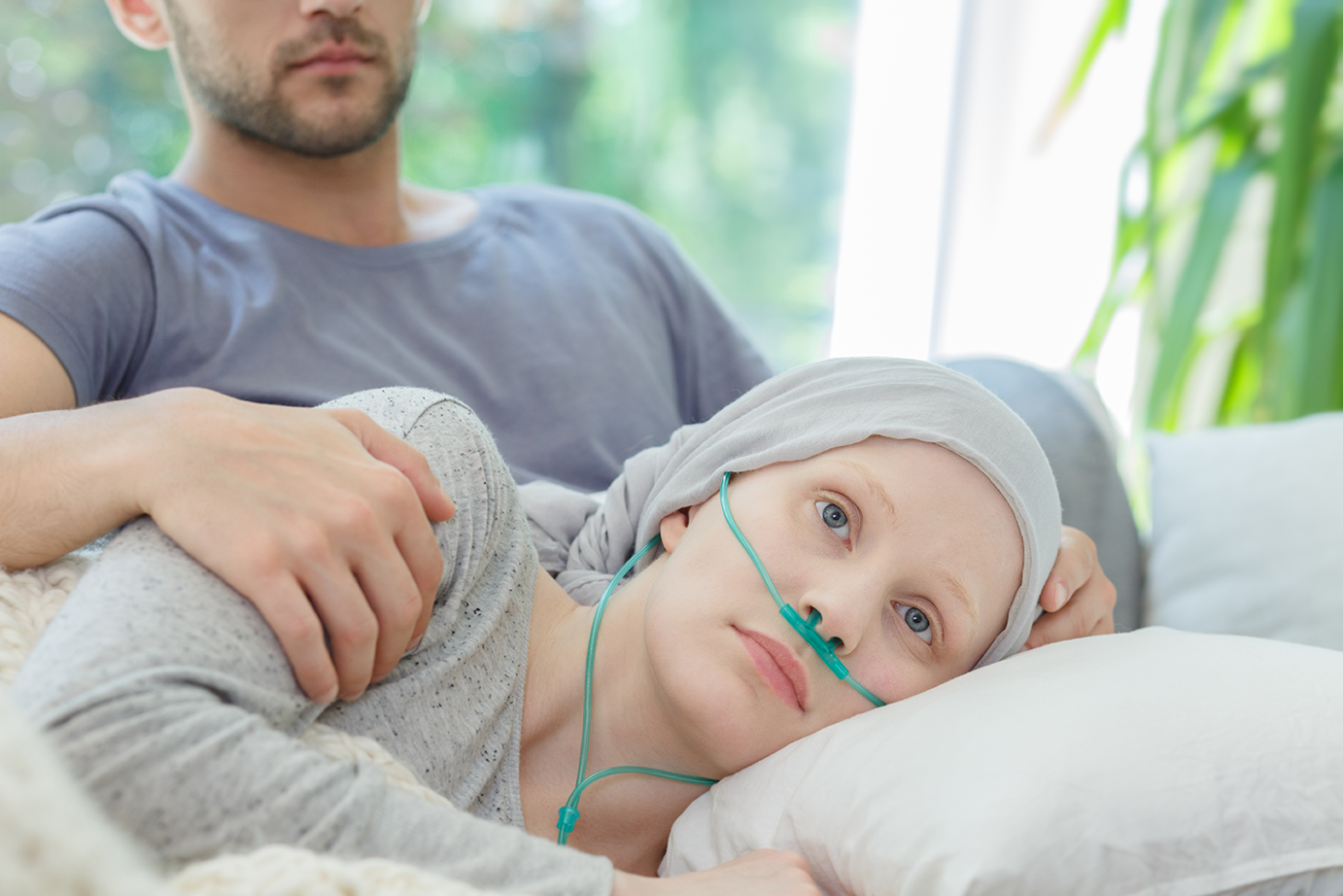 Young sad woman resting with oxygen nasal cannula on